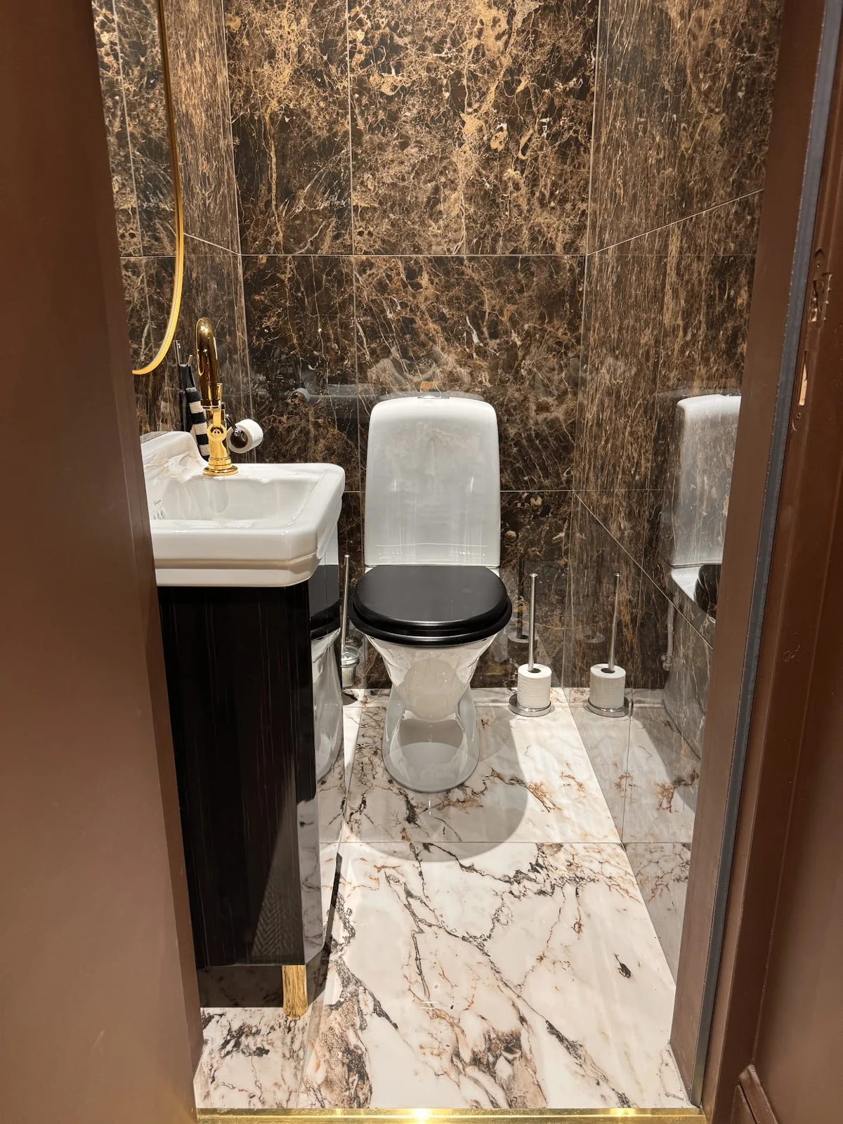 WC avec revêtements effet pierre et robinetterie dorée